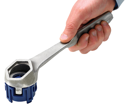 2479100 - Fass Spundschlüssel für Drehmoment-Einsatz (DrumQuik PRO) in Anwendung: Spezialwerkzeug zum sicheren Öffnen und Schließen von Fassverschlüssen. Eine Hand hält den silberfarbenen 2479100 - Fass Spundschlüssel für Drehmoment-Einsatz (DrumQuik PRO), der auf einen blauen Fassverschluss aufgesetzt ist.