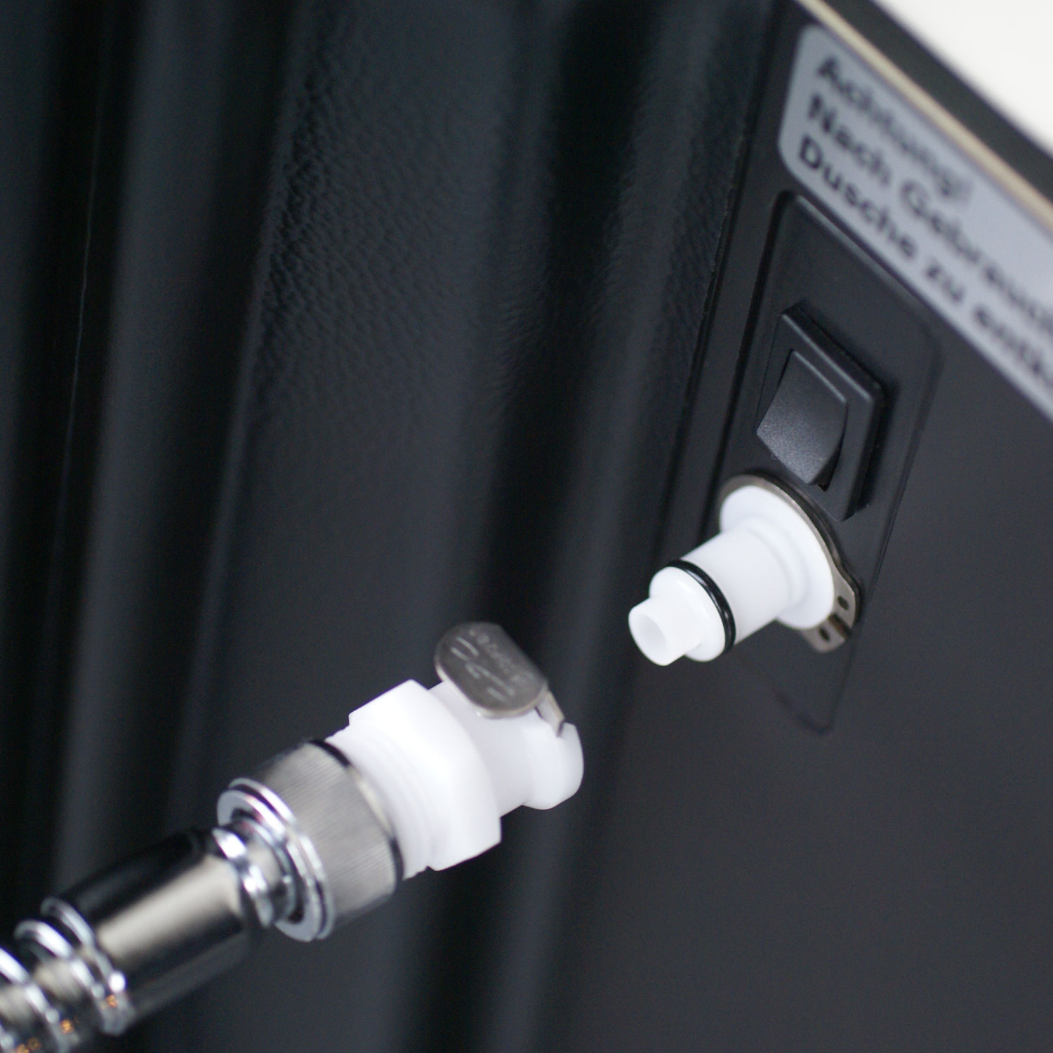 Westfalia Camping Dusche: Präzise Kupplung für Brause-Anschluss. Zeigt den weißen Stecker und die Anschlussbuchse für einfaches und sicheres Verbinden des Duschschlauchs. Kupplung Brause-Anschluss für Westfalia Camping Dusche. Detailaufnahme des weißen Steckers vom Brauseschlauch und der passenden Buchse am Duschgerät, bereit zur Verbindung.