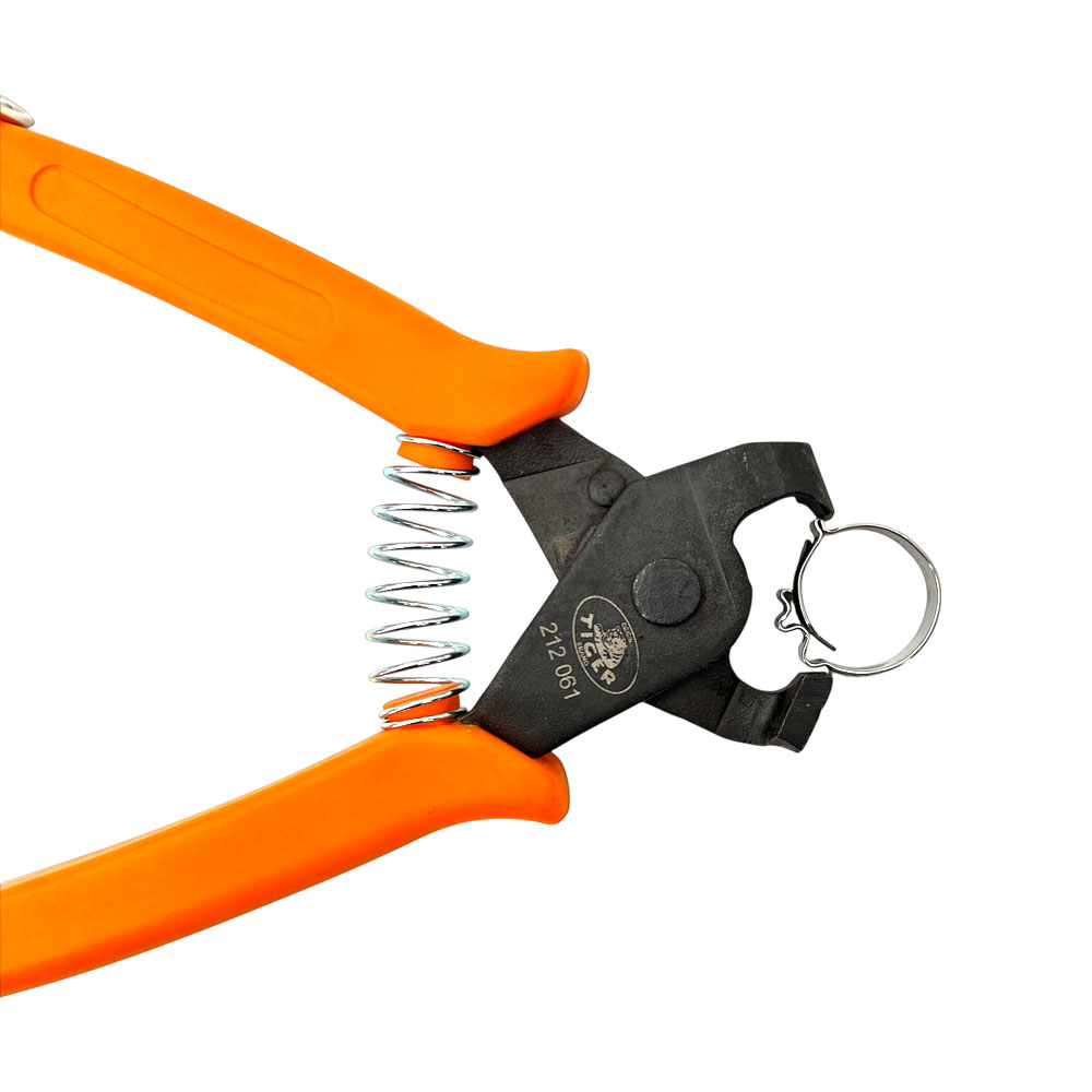 Eine Schlauchklemmen-Zange für COBRA, CLIC und CLIC-R Schlauchschellen mit orangefarbenen, ergonomischen Griffen und schwarzem Zangenkopf, die eine silberne Schlauchschelle festhält. Die Zange zeigt eine offene Feder zwischen den Griffen auf weißem Hinter